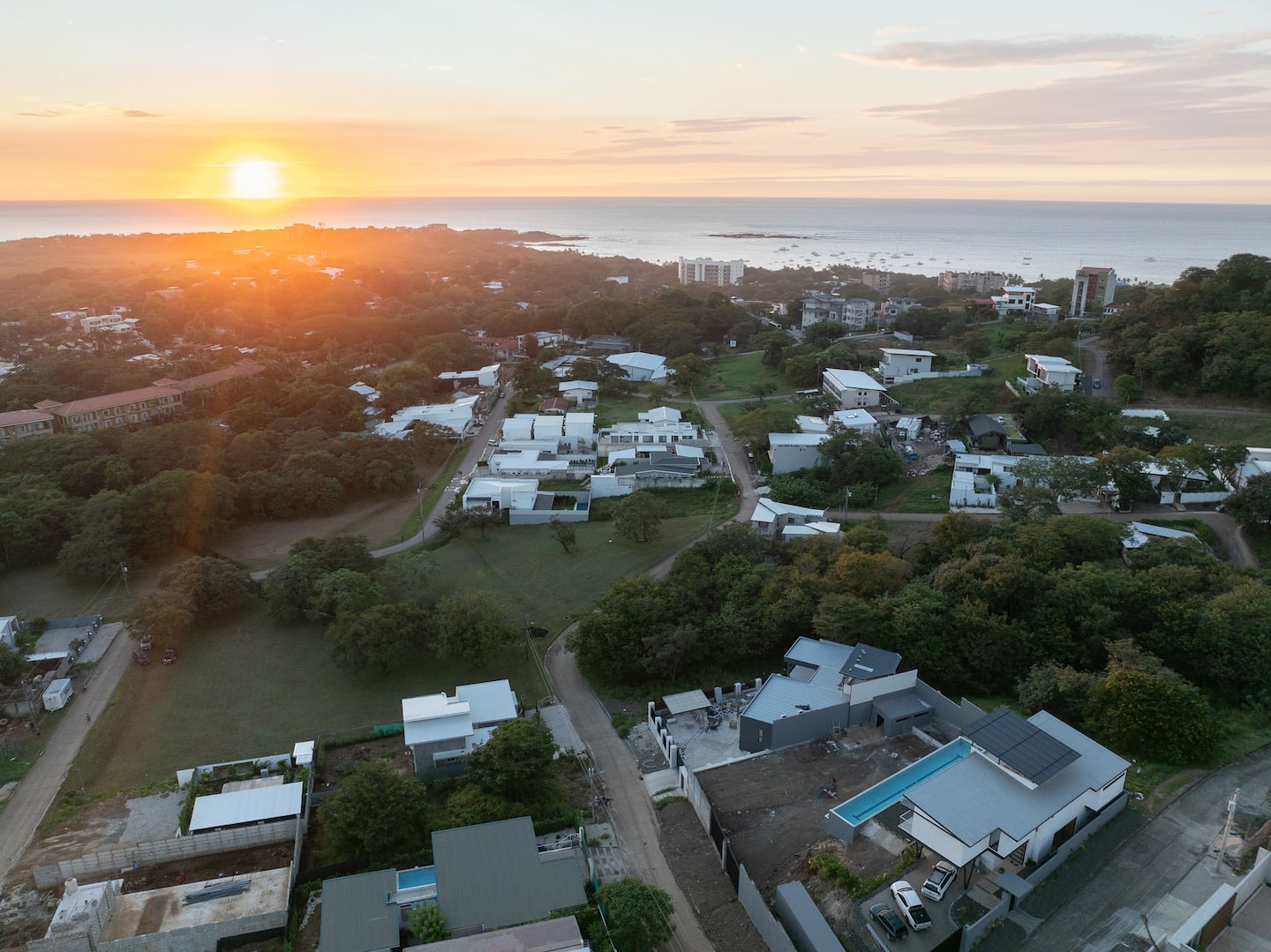 Aerial view of Tamarindo at sunset, with the town, the dry forest and the Pacific beyond